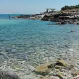 La prima caletta che ci troviamo davanti si presenta come una piccola insenatura dominata da tanti piccoli ciottoli bianchi che lasciano spazio alla sabbia non appena si entra in acqua, che qui appare di un colore azzurro cristallino